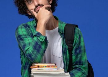 cropped-front-view-male-student-green-checkered-shirt-with-black-backpack-thinking-holding-copybooks-files-blue-wall-scaled-1.jpg