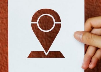 hand-hold-pin-tag-paper-carving-with-red-background_53876-41424