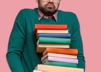 indoor-shot-puzzled-unshaven-man-wears-spectacles-holds-many-handbooks-feels-doubt_273609-24736