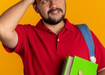 young-bearded-student-guy-red-polo-shirt-with-backpack-holding-notebooks-looking-aside-confused-with-hand-his-head-mistake-standing_141793-98929