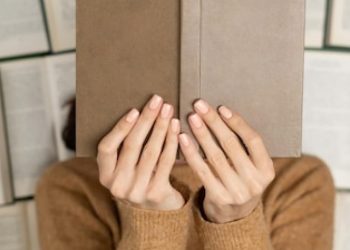 top-view-girl-cozy-soft-sweater-lies-open-books_343596-7948