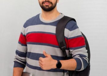 Portrait,Of,Handsome,Indian,Man,Holding,A,Laptop,On,White